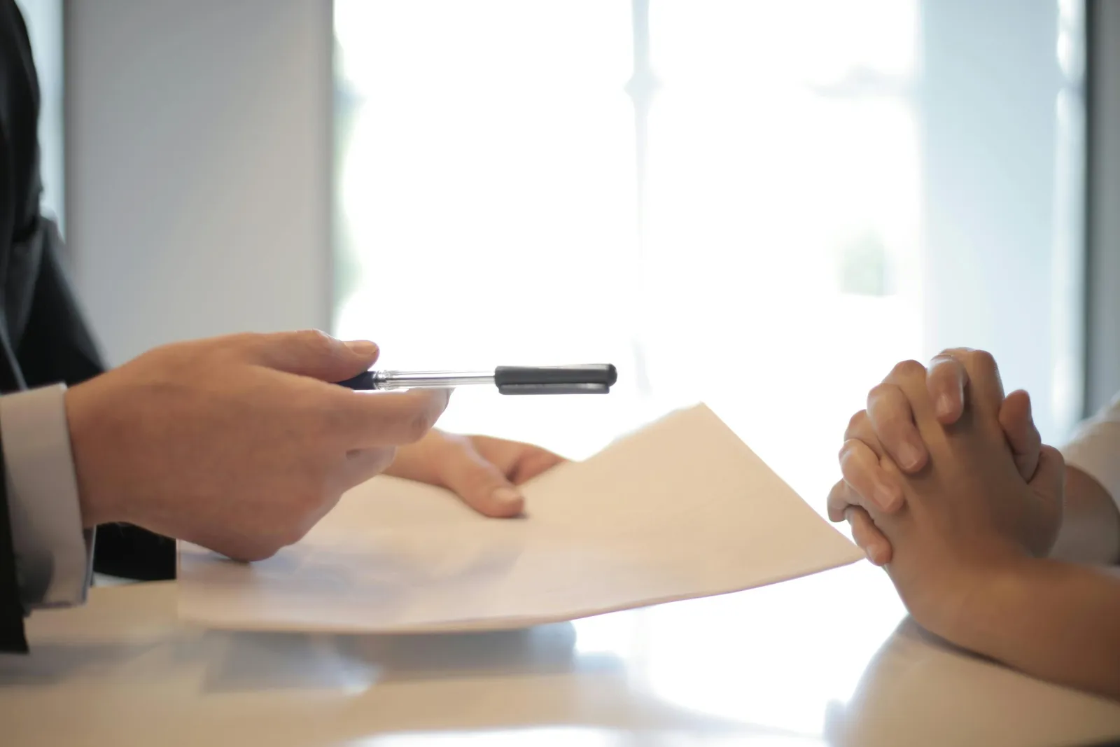 Two people at a desk reviewing and signing a consulting agreement